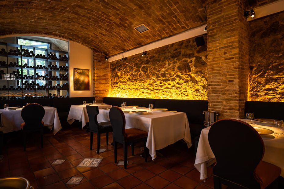 Intérieur du restaurant Spondi à Athènes, mur en pierre, bois, lumière chaude