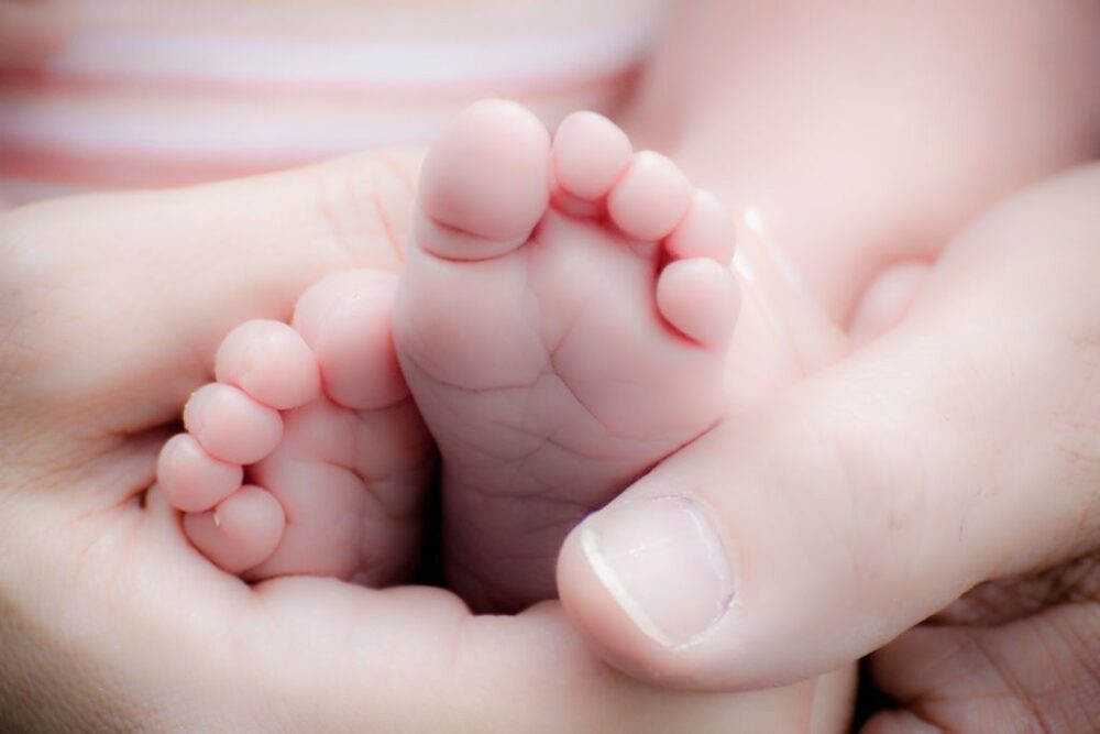 Prénoms grecs : pieds d'un bébé dans les mains d'un père