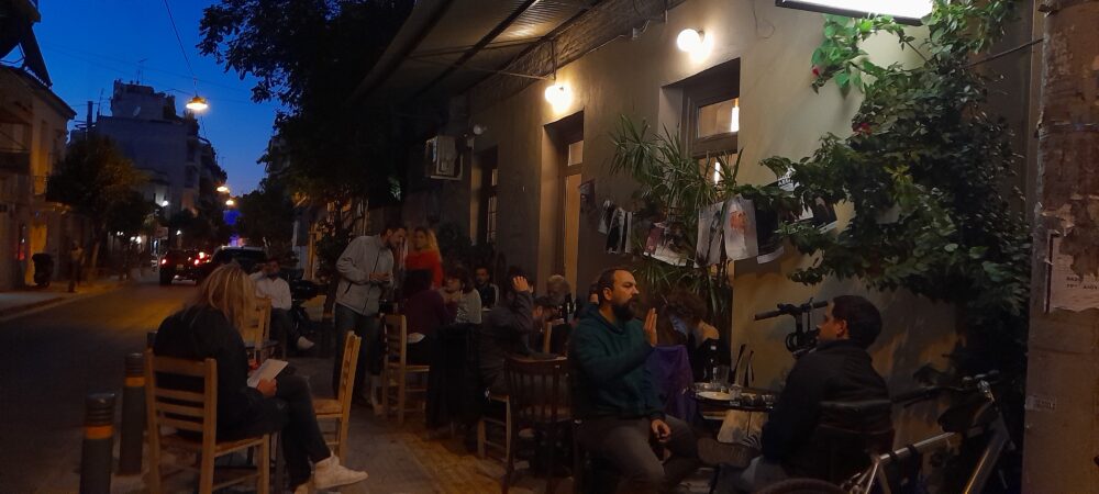Terrasse animée d'un bar la nuit dans une rue de Metaxourghio à Athènes