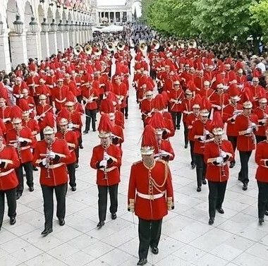 défilé d'une fanfare militaire, uniformes rouges
